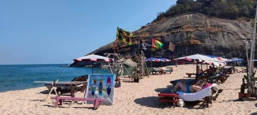 a beach with a bunch of chairs and umbrellas at Turtle Nest in Khao Tao