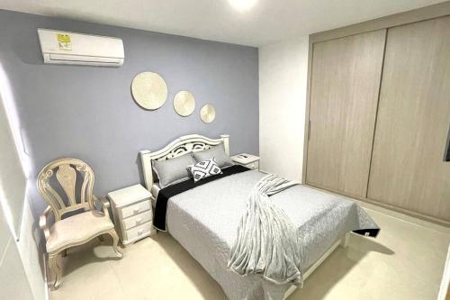 um quarto com uma cama e uma cadeira em Apartamento con vista a las montañas, cerca Centro Comercial Mayales em Valledupar