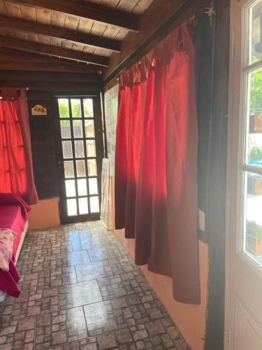 una habitación con cortinas rojas en la pared y una puerta en Anmery departamento en Mar del Plata