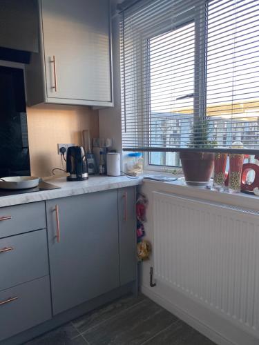 a kitchen with white cabinets and a counter top at Jmk home in Lexden