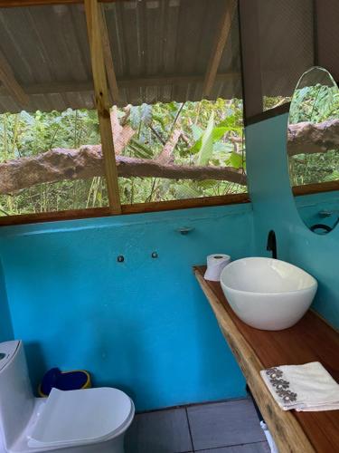 a bathroom with a sink and a toilet and a window at Finca la Bonita, Playa Carate in Carate