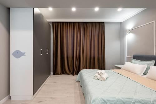 ein Schlafzimmer mit einem Bett mit zwei Handtüchern darauf in der Unterkunft One Bedroom Apartment Near Arbat In The Heart of Almaty in Almaty