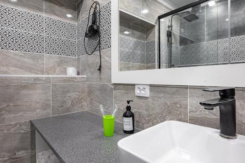 ein Badezimmer mit einem Waschbecken und einer Flasche Wein auf der Theke in der Unterkunft One Bedroom Apartment Near Arbat In The Heart of Almaty in Almaty