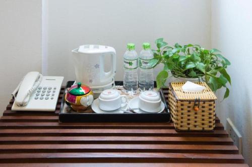 uma bandeja com comodidades para preparar café e um telefone sobre uma mesa em NT Elysian hotel em Hanói