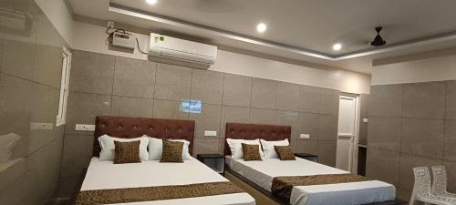 a bedroom with two beds and a air conditioner at Selvasi Beach Cottage in Auroville