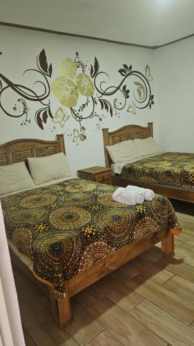 貝納爾的住宿－Posada villa aurora，卧室配有两张床,墙上挂有壁画