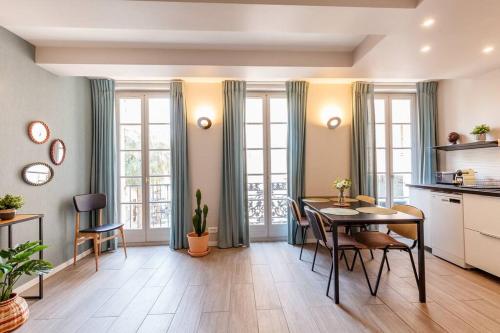 une cuisine et une salle à manger avec une table et des chaises dans l'établissement Appartement élégant plein centre, à Toulon