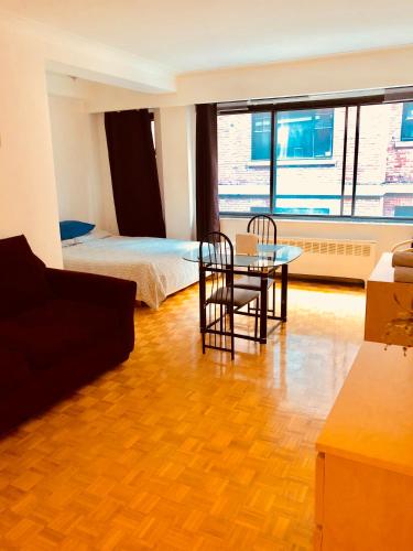 uma sala de estar com uma mesa e cadeiras e uma cama em Stylish Montreal Apartment: Comfortable Stay in the Golden Square Mile em Montreal