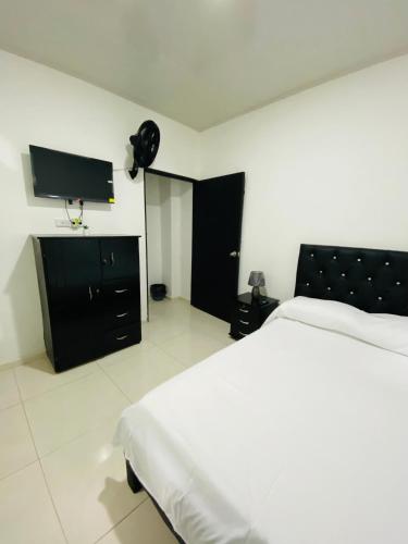1 dormitorio con 1 cama y TV de pantalla plana en Alojamientos Z.V, en Tumaco