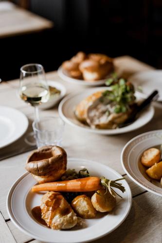a table with plates of food and a glass of wine at The Duke William in Canterbury