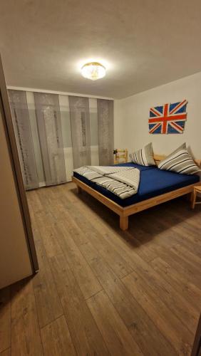 1 dormitorio con 1 cama con bandera en la pared en Doppelzimmer in FEWO Burgau Nähe Legoland, en Burgau