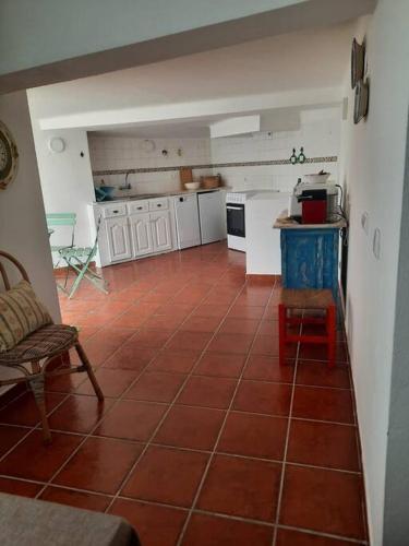 a kitchen with a red tiled floor in a room at Casa da Avó Dada in Torrão