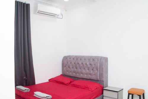 a bedroom with a gray bed with red sheets at Qiu's Event House Std Double Room in Kuala Berang