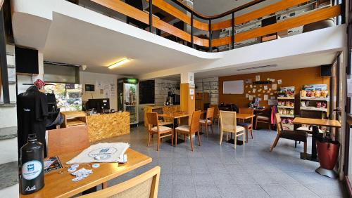 ein Restaurant mit Tischen und Stühlen in einem Zimmer in der Unterkunft Traveler Hostel in Shkodra
