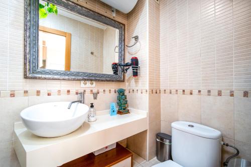 ein Badezimmer mit einem Waschbecken, einem Spiegel und einem WC in der Unterkunft Ático de Lujo Plaza Ayuntamiento in Valencia