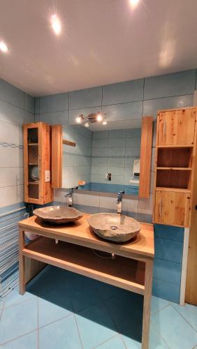 - une salle de bains avec deux lavabos sur un comptoir en bois dans l'établissement Chalet Coquelicot confort cosy au coeur du village de Saint Martin, à Saint-Martin-de-Belleville
