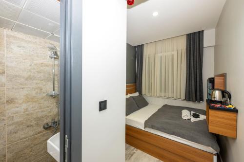 a small bedroom with a bed and a shower at mayza otel in Istanbul
