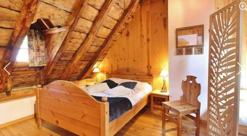 une chambre avec un lit dans une pièce aux murs en bois dans l'établissement La Maison d'Aimée, à Vielle-Aure