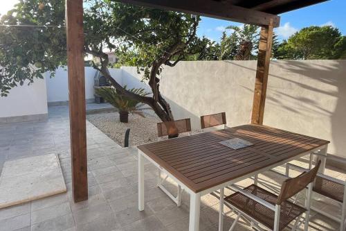 einen Holztisch und Stühle auf einer Terrasse in der Unterkunft Casa indipendente in Tonnara di Bonagia