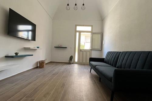 ein Wohnzimmer mit einem Sofa und Holzboden in der Unterkunft Casa indipendente in Tonnara di Bonagia