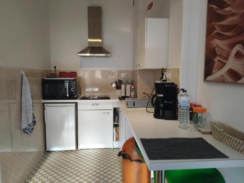 une cuisine avec des armoires blanches et un comptoir dans l'établissement Nice appartement centre, à Nice