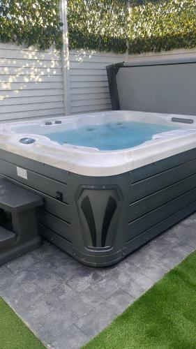 a jacuzzi tub with a bench in a yard at The Chroma Cottage in Cock Hill