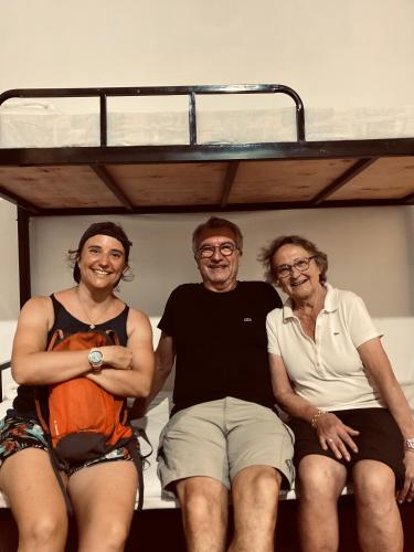a group of three people sitting on a bunk bed at Railway Hostel in Matara