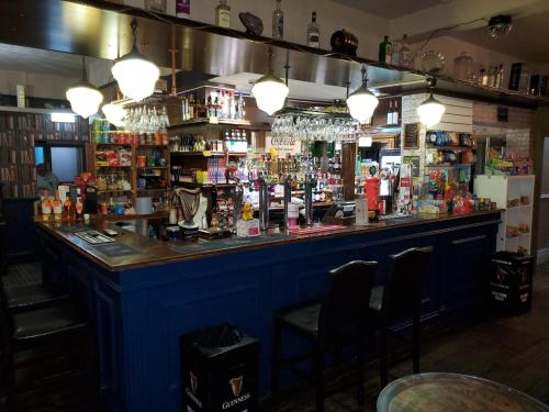 a bar with a blue counter and some chairs at The Queens Arms Hotel in Acomb