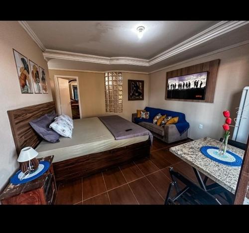 a bedroom with a large bed and a couch at Equilibrium Pousada Familiar (orquídeas) in Torres