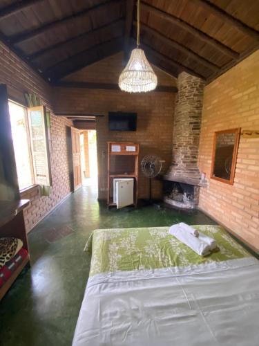a bedroom with a large bed and a fireplace at Pousada Chalés Vale do Sol in Conceição da Ibitipoca