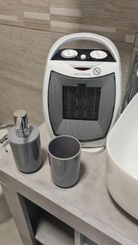 a toaster and two cups on a table in a bathroom at CASA VACANZA PARADISO in Manfredonia