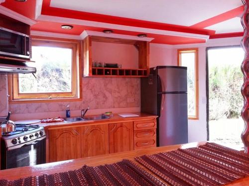 Una cocina con refrigerador de acero inoxidable y gabinetes de madera. en Portal de los Andes Bariloche, en San Carlos de Bariloche
