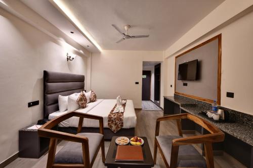 une chambre d'hôtel avec un lit et une table dans l'établissement Click Sunburry Hotel Katra, à Katra
