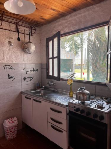 cocina con fregadero, fogones y ventana en Recodo de mar, en Aguas Dulces