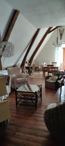 - un salon mansardé avec des canapés et des chaises dans l'établissement La Grange du ratier, à Padirac