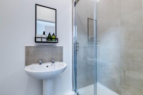 uma casa de banho com um lavatório e um chuveiro com um espelho. em Apt 1 - Empire 39 - Central Location em Scarborough