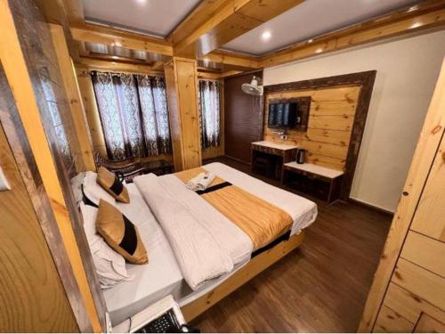 una camera con un grande letto e una scrivania di Near Reliance Mall Hotel Green Land a Darjeeling