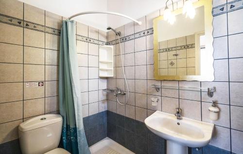 een badkamer met een wastafel, een toilet en een spiegel bij Elaida Apartments in Apollonia