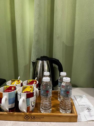 a tray with bottles of water and bowls of food at S8 Boutique Hotel near KLIA 1 & KLIA 2 in Sepang