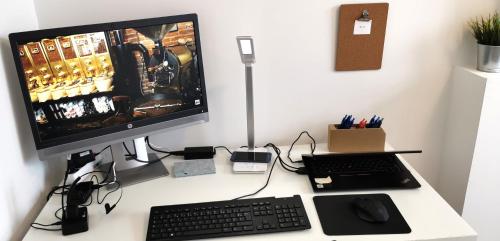a desk with a computer monitor and a keyboard at Reims Appart - Idéal pour Pro en déplacement *Wifi rapide *Vue panoramique *Parking facile in Roubaix