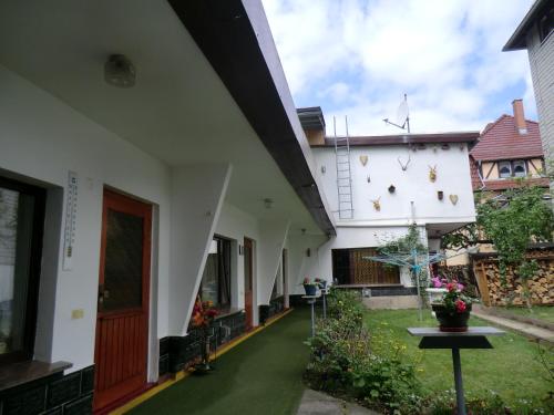 a courtyard of a white building with a green floor at Pension Villa Brödel in Bad Blankenburg