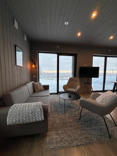 sala de estar con sofá, sillas y piano en Toppvillan - Ski In - Ski Out - 200 m till toppen och cykelleder, en Järvsö