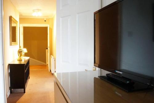 a living room with a flat screen tv on a wall at Large Apartment in Rothesay on The Isle of Bute in Rothesay