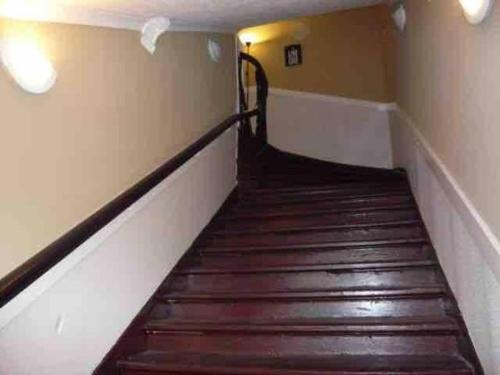 a staircase in a building with wooden steps at Large Apartment in Rothesay on The Isle of Bute in Rothesay