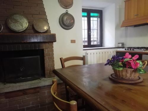 eine Küche mit einem Holztisch und einem Kamin in der Unterkunft VAL GRANDE APARTMENT in Miazzina