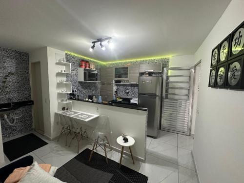 a small kitchen with a counter and a refrigerator at Aero-Quarto Aconchegante in Bayeux