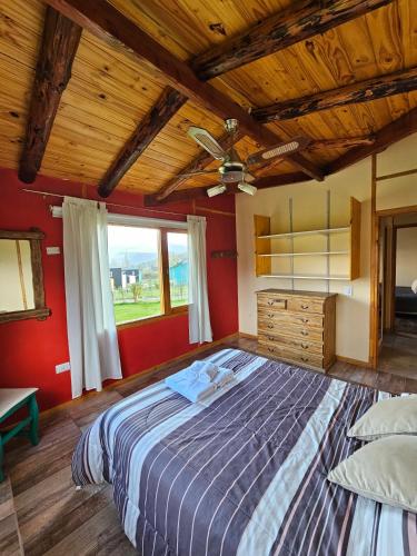 a bedroom with a large bed with a wooden ceiling at La Yaya - Villa Turismo in El Bolsón