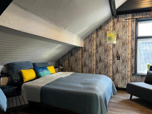 1 dormitorio con 1 cama, 1 silla y 1 ventana en Bed&Breakfast Jonker, en Burgh Haamstede