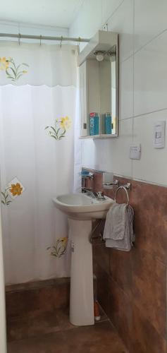 a bathroom with a white sink and a mirror at Casa con PILETA, PARRILLA y cochera cubierta in Chascomús