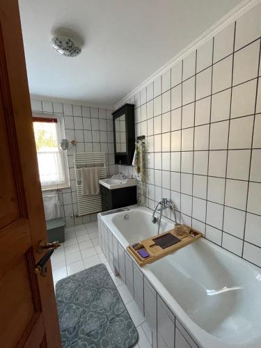 a white bathroom with a tub and a sink at Haus Edeltraut in Bad Mitterndorf